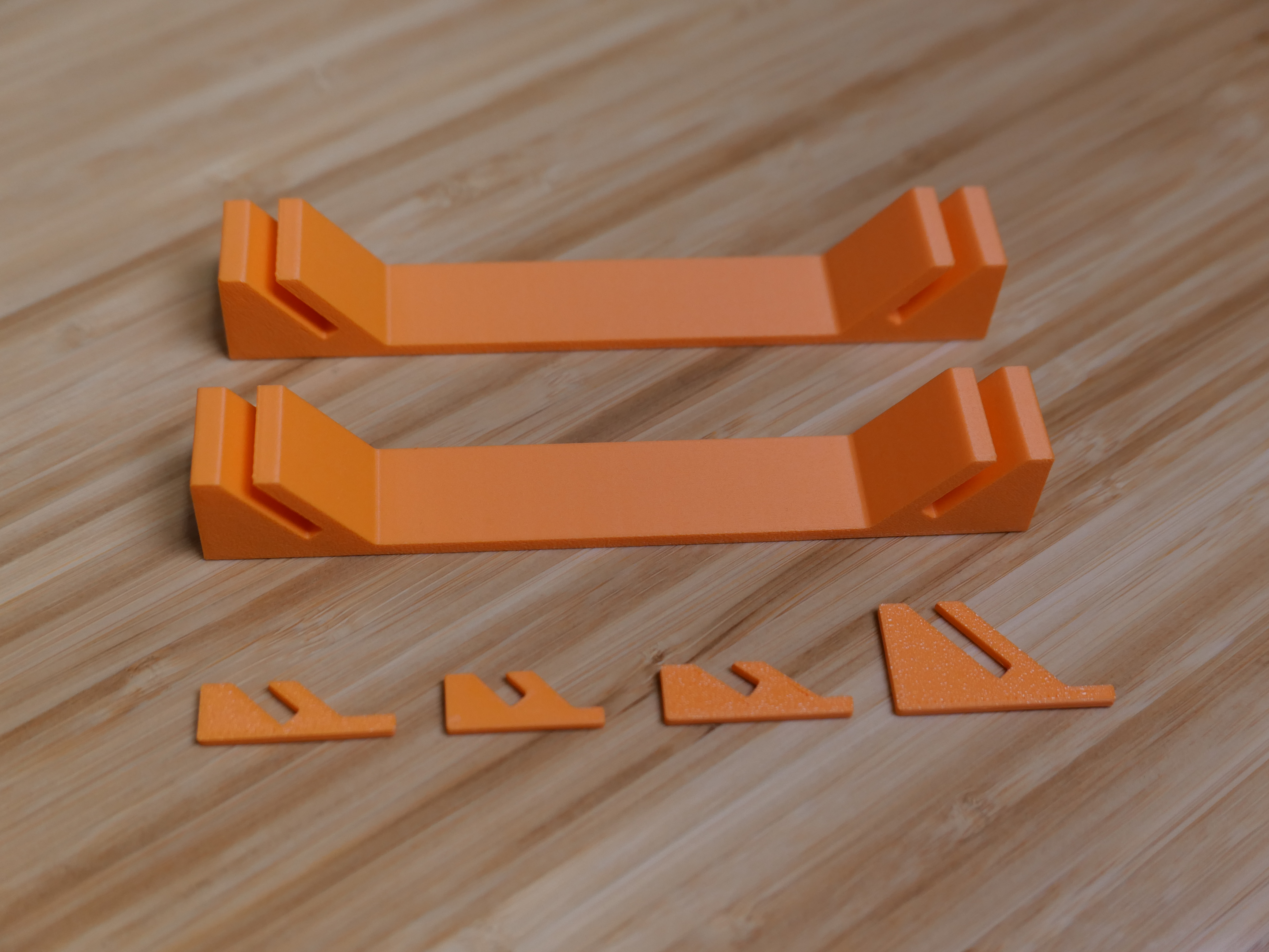 Photo showing four prototype coupons and two printed full-scale brackets